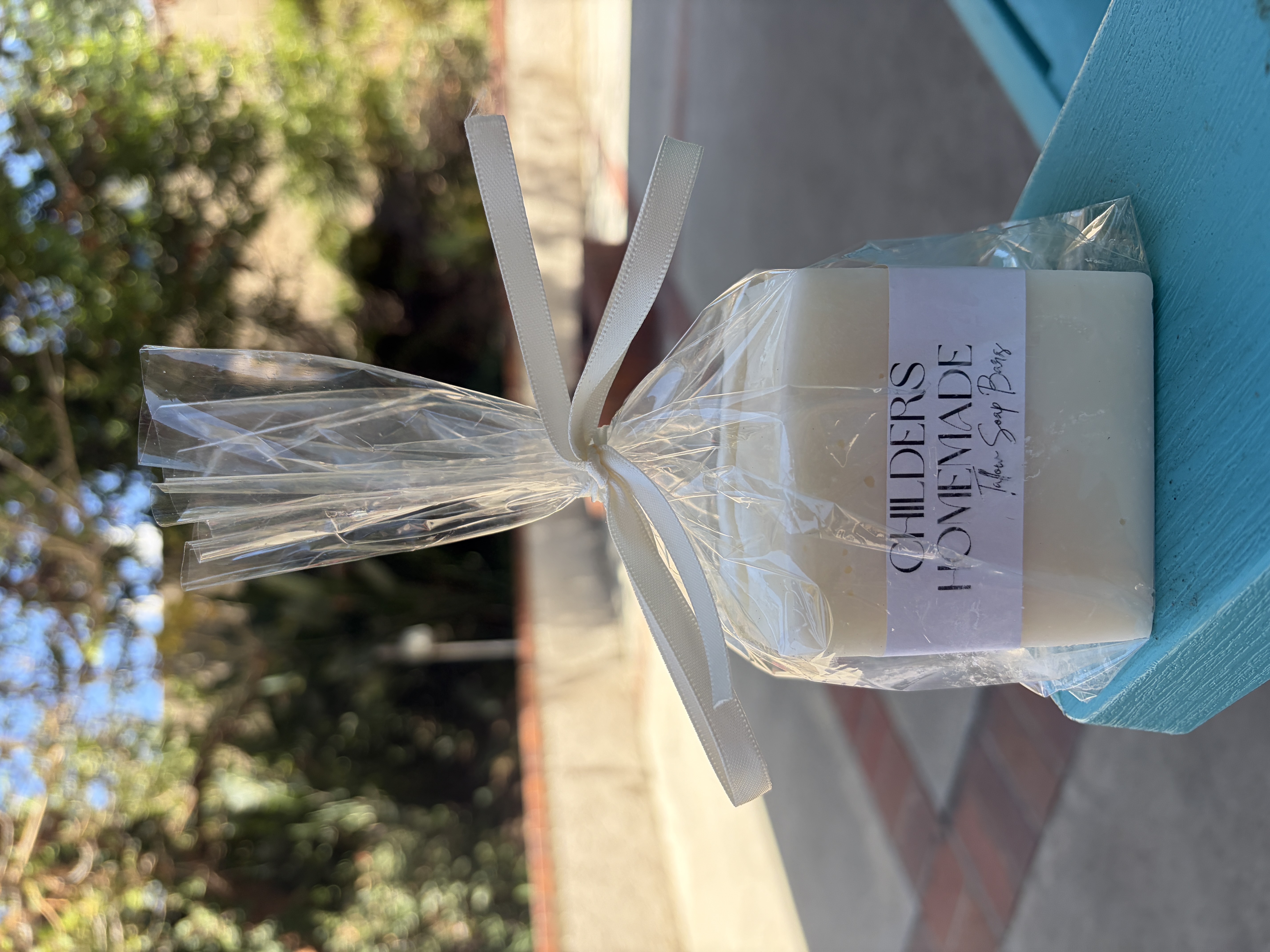 A Childers Homemade soap bar wrapped in a clear gift bag and tied with a white ribbon